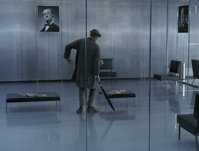 Jacques Tati filmis „Playtime” (1967) keeldub härra Hulot teda ümbritsevat vaatemänguühiskonda tõsiselt võtmast. Kaader filmist