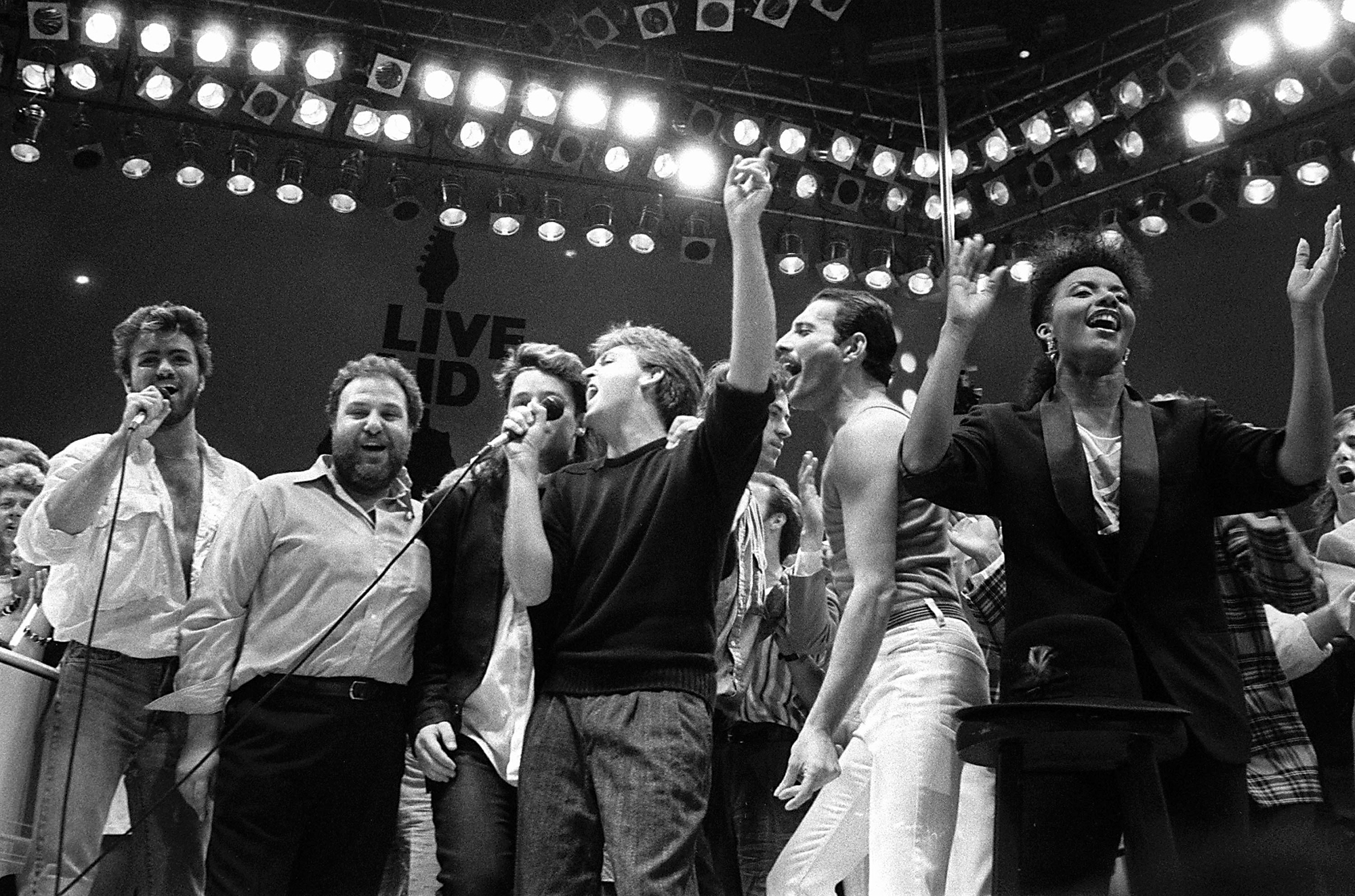 13. juuli 1985, George Michael, Harvey Goldsmith, Bono, Paul McCartney, Bob Geldof ja Freddie Mercury juubeldavad Live Aid kontserdil Londonis. Foto: Joe Schaber / AP Photo / Scanpix